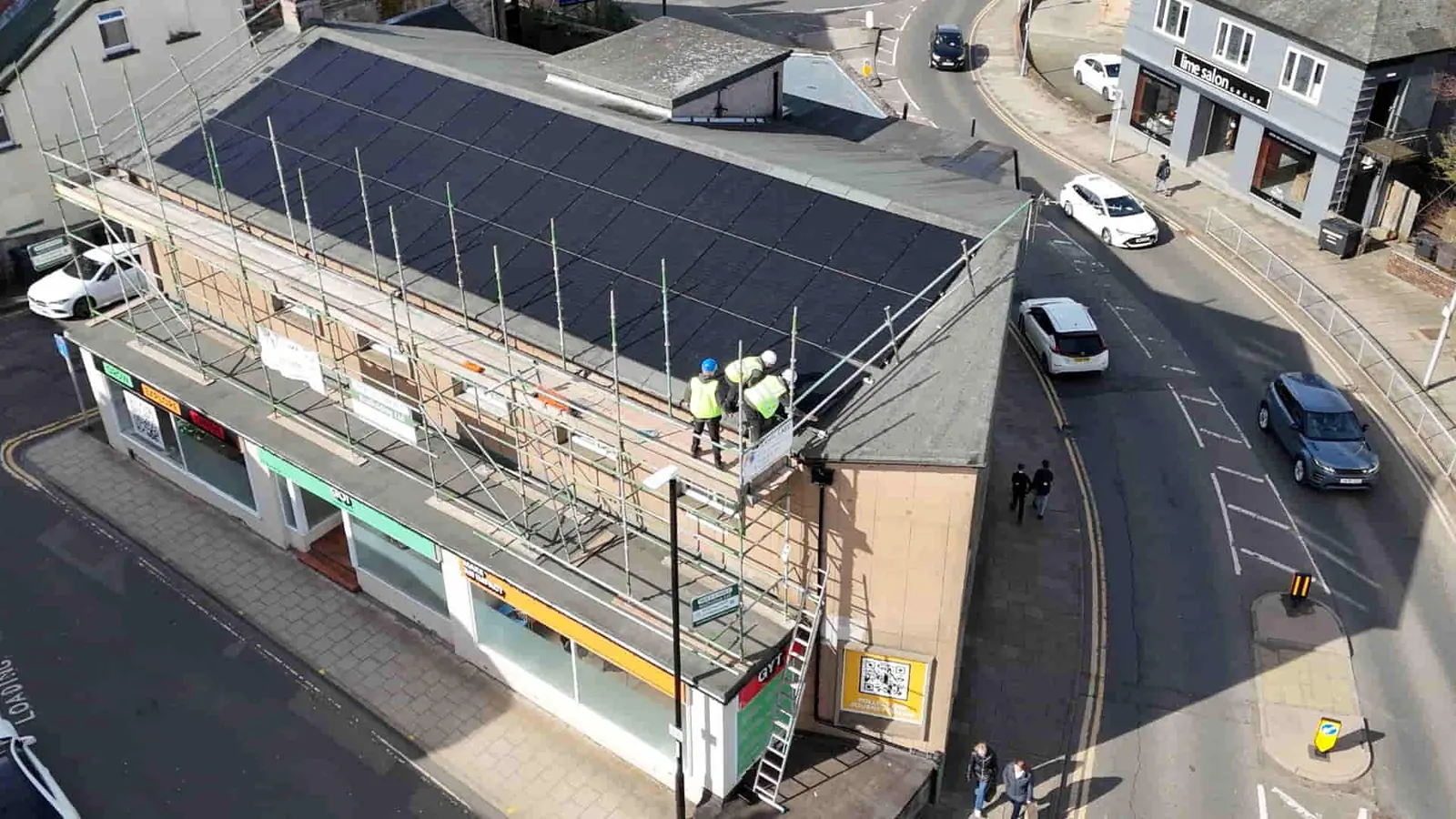 Thermal Care engineers installing rooftop solar panels on a commercial building in a Scottish town centre