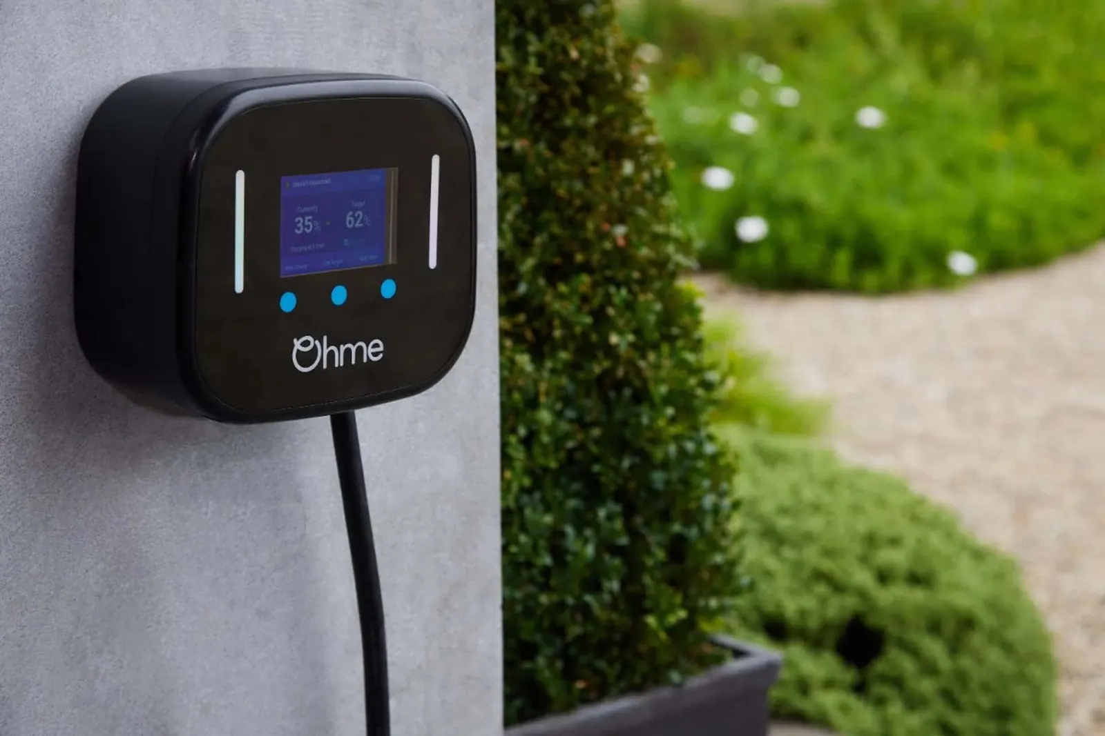 Ohme smart EV charger on a home wall