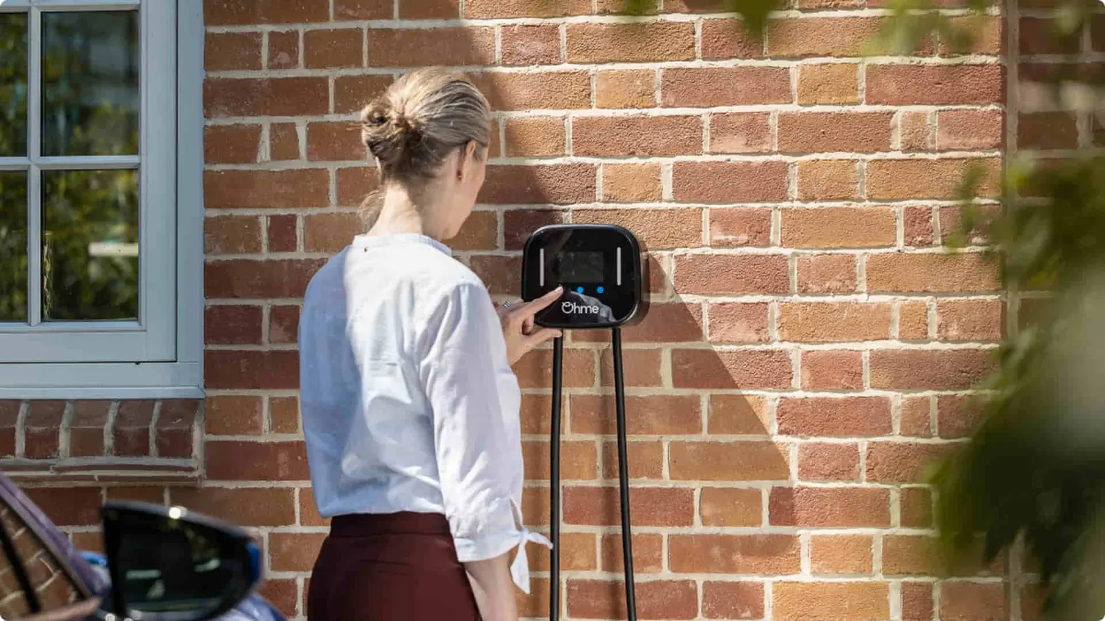Homeowner using a wall-mounted EV charger