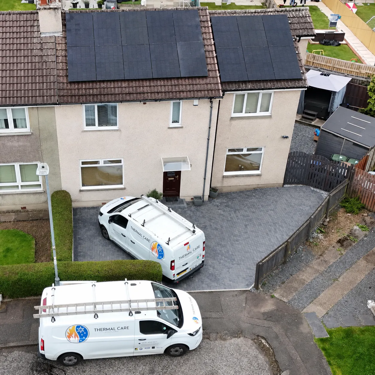 Thermal Care vans at a house with a rooftop solar installation