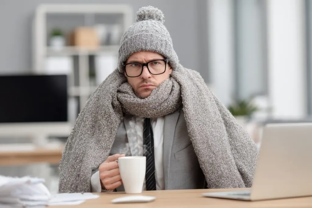 Cold Office Workers In Winter waiting on the heating system to be repaired