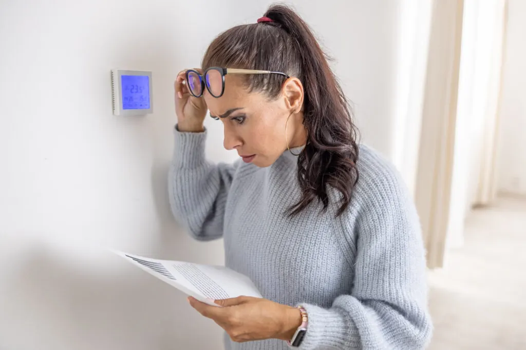 Homeowner reviewing high energy bills caused by boiler not working efficiently
