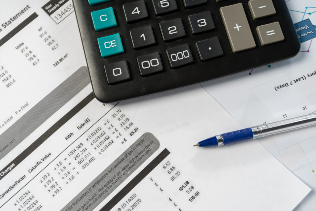 Energy bills and calculator showing cost savings from regular commercial boiler service for Scottish businesses