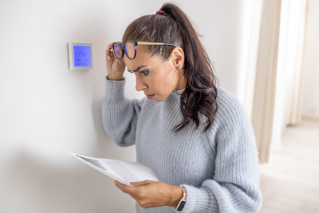 Homeowner reviewing high energy bills caused by boiler not working efficiently
