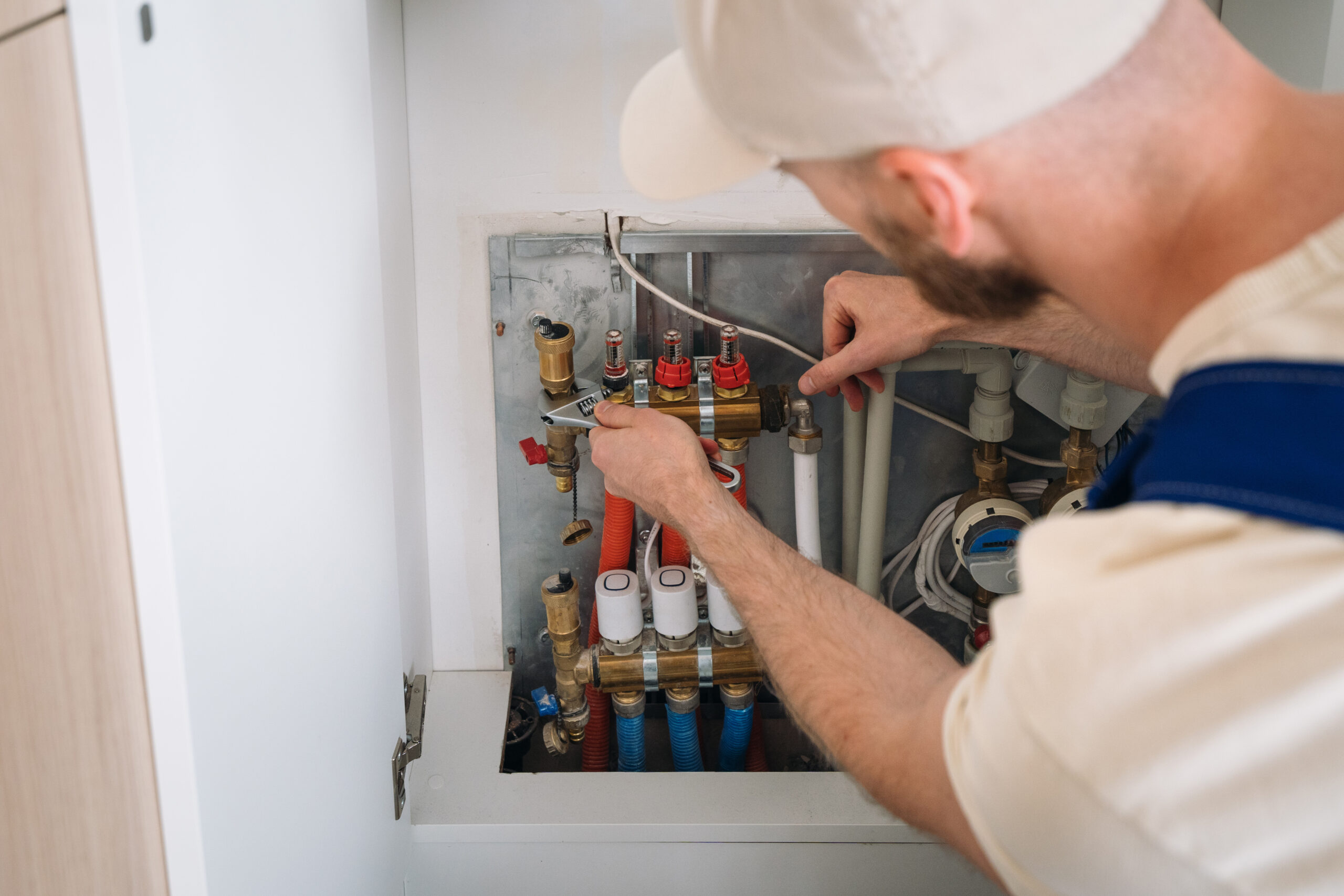Gas Safe registered engineer repairing boiler heating system manifold in Scottish home